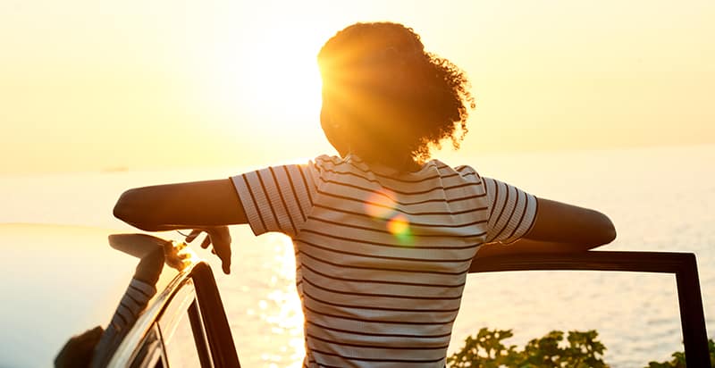 An image of a woman looking out at a sunrise, embodying the blog's message about the significance of mental health during and after the transition from incarceration.