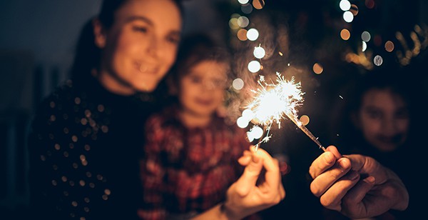 A family holding sparklers, embodying the significance of New Year's resolutions, especially for those post-incarceration, as they embrace fresh starts and set positive intentions for the future.