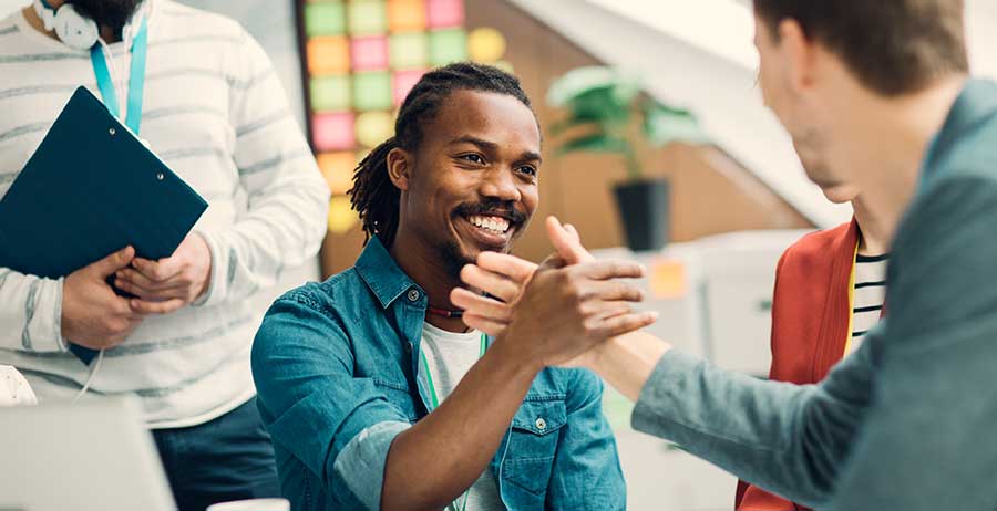 Two men shake hands, symbolizing the journey of rebuilding personal and professional relationships after incarceration, forging paths towards trust and renewal.