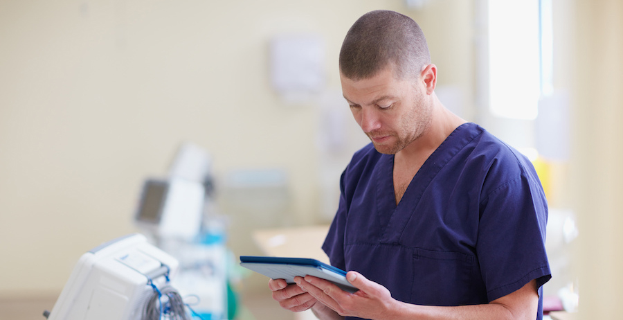 Image shows a doctor reading a patient’s chart, representing the opportunity for free health insurance upon reentry.