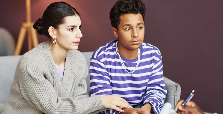 Worried mother providing support to her teenage son in a reentry program, fostering a positive environment for personal growth and rehabilitation.