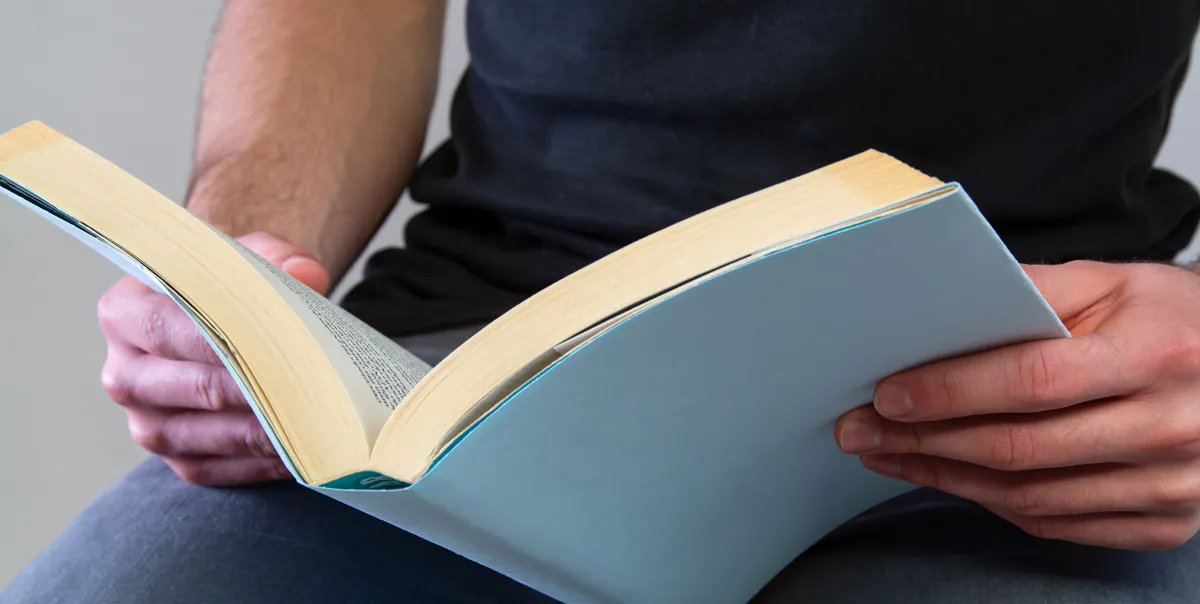 Close-up of a man reading, illustrating the importance of education and self-improvement in overcoming challenges as it did for Shaka Senghor.