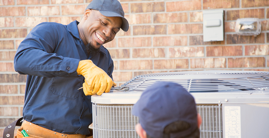 Air conditioner repairmen at work, preparing to begin work by gathering appropriate tools from their toolbox.