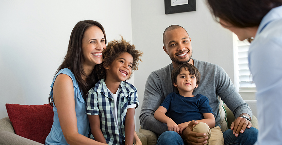 Family of four meeting with a reentry counselor to discuss plans and support after a loved one’s release from prison.