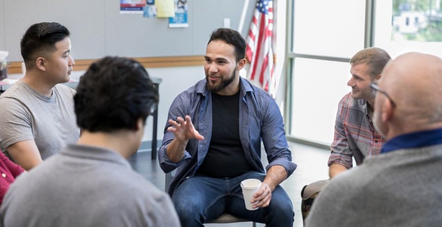 a man speaking leading a group therapy session