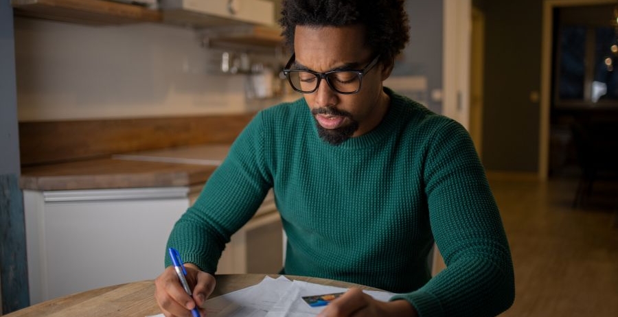 Man reviewing his finances at home, representing life after prison and rebuilding financial stability.