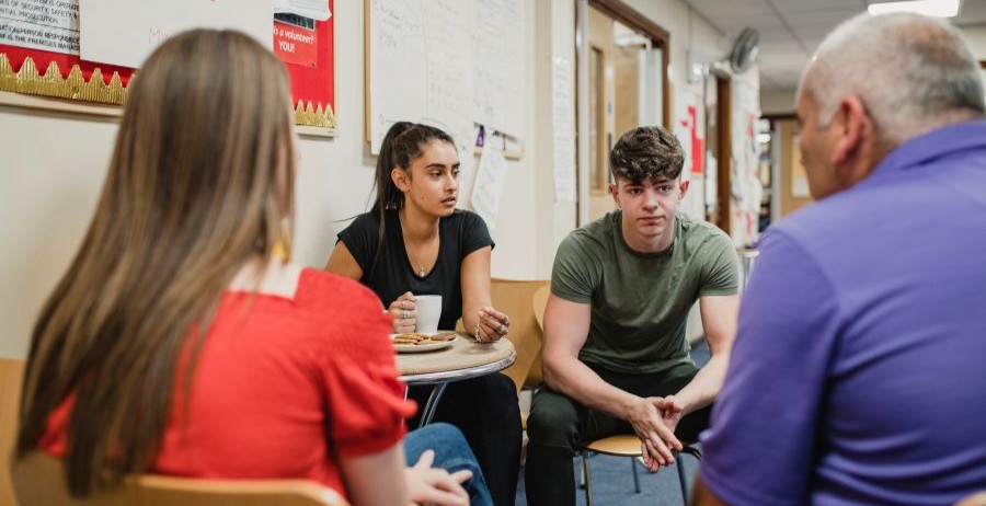 Youth participate in a substance use rehab session with an adult facilitator, discussing recovery, support, and treatment options for juveniles.